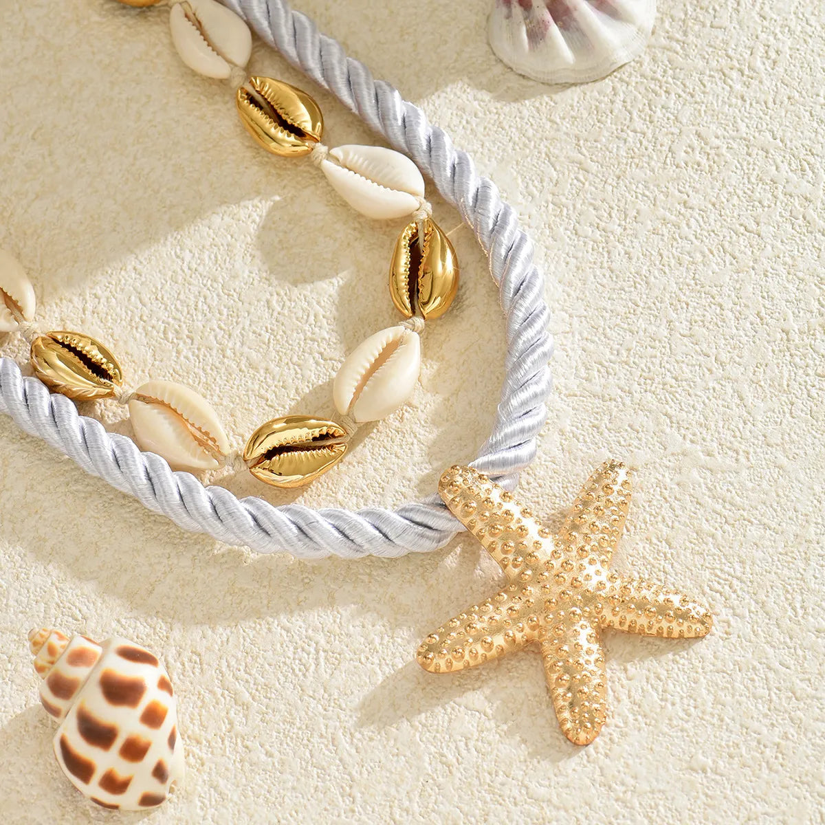 Gold-tone boho necklace set with shell beads, starfish pendant, and white rope chain.