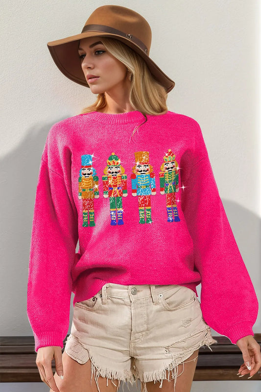 Blush sequin nutcracker long sleeve sweater on a model with wide-brim hat and shorts.