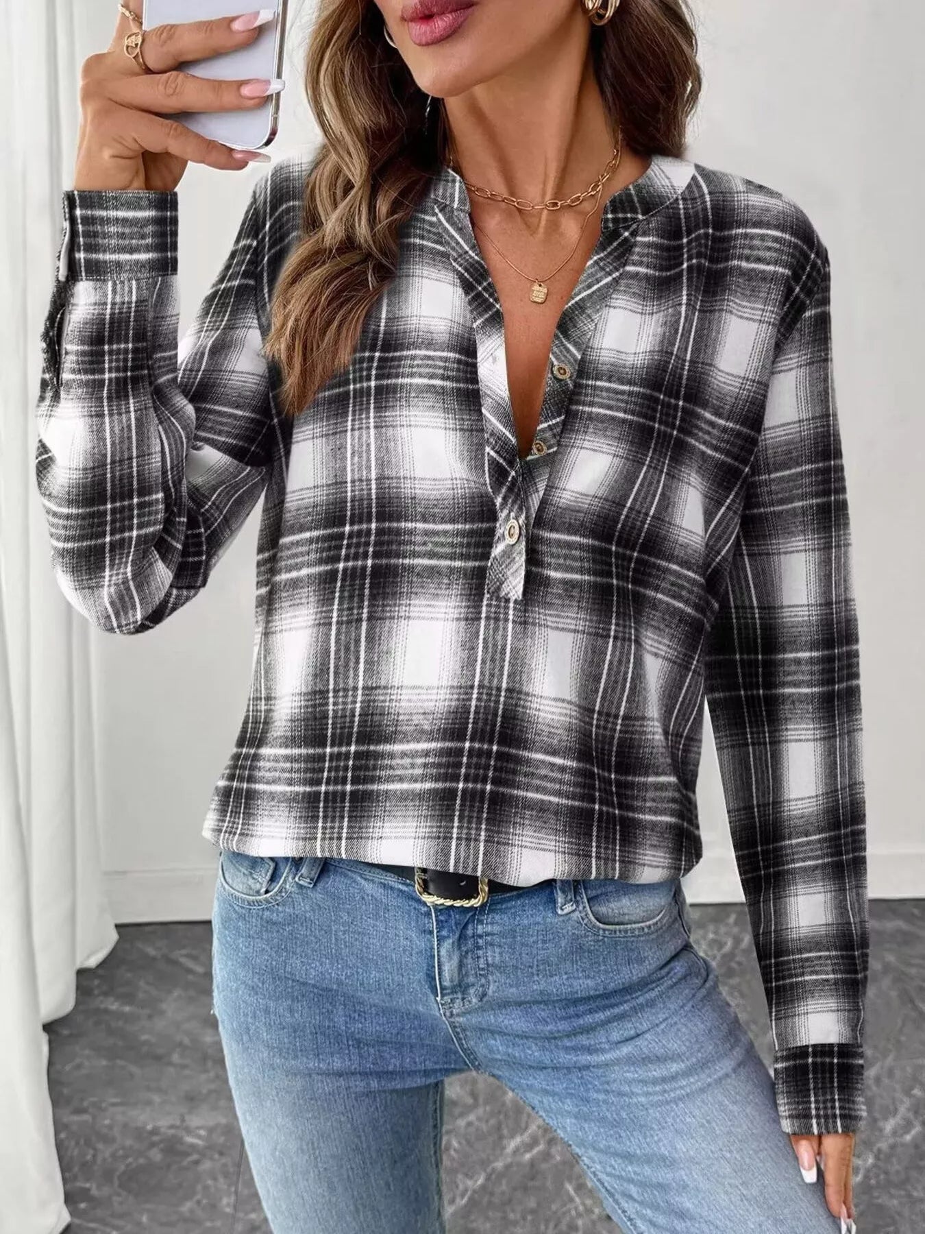 Plaid long sleeve blouse with half button closure, made of polyester and spandex blend.