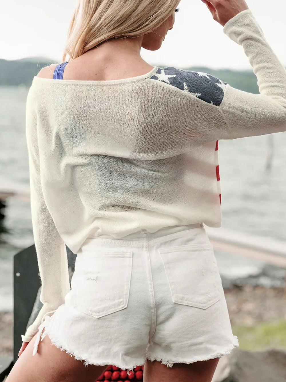 Long sleeve boat neck knit top with US flag design, made of 100% acrylic.