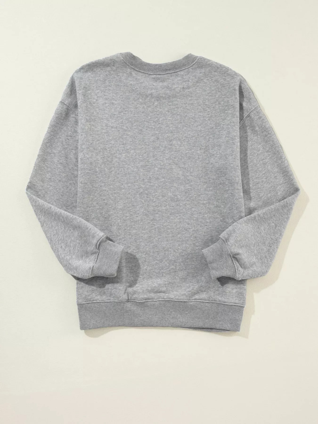 Light gray sweatshirt with festive letter print and drop shoulder design in a cotton blend.