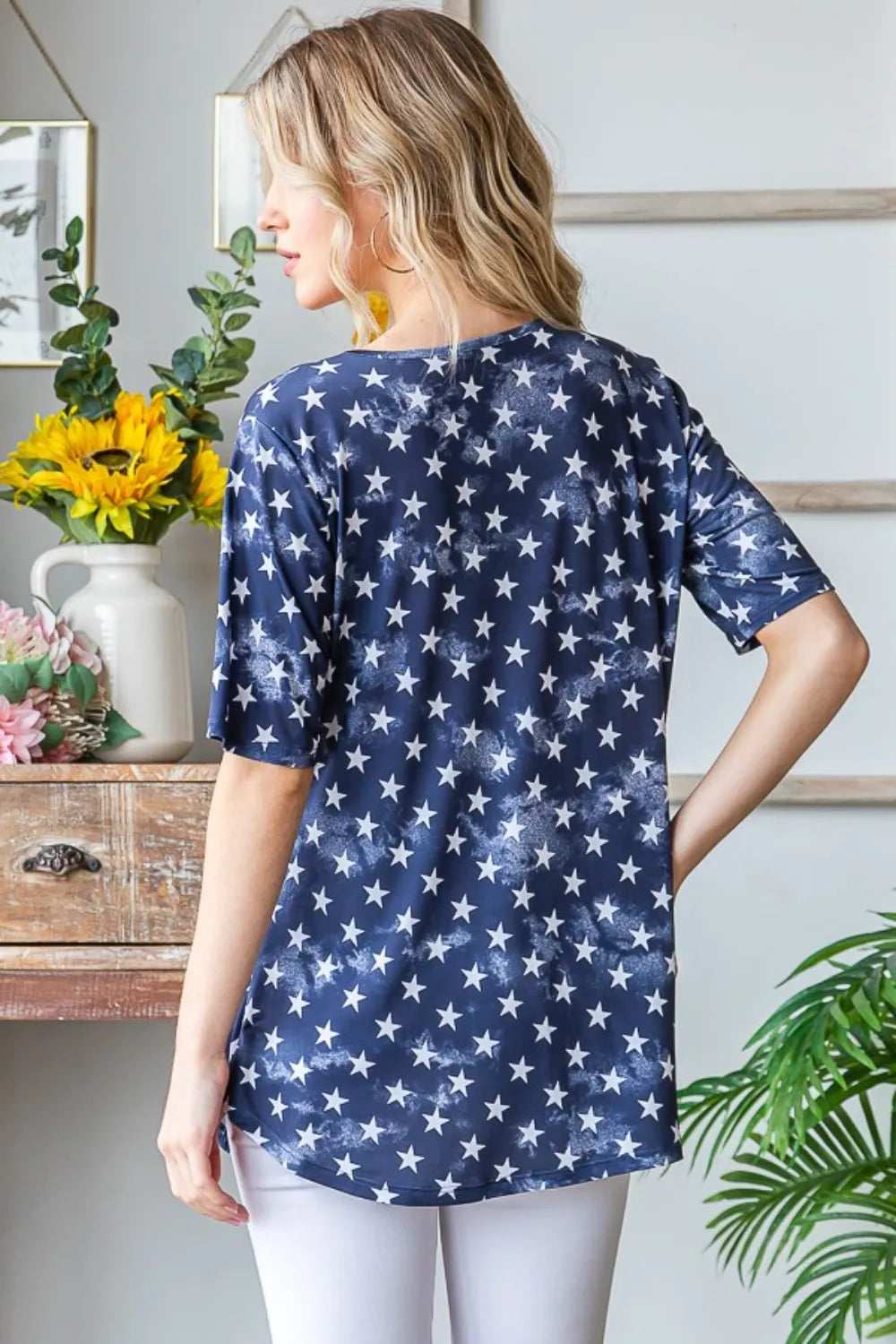 Short sleeve babydoll top with crisscross detail and playful star print on a relaxed silhouette.