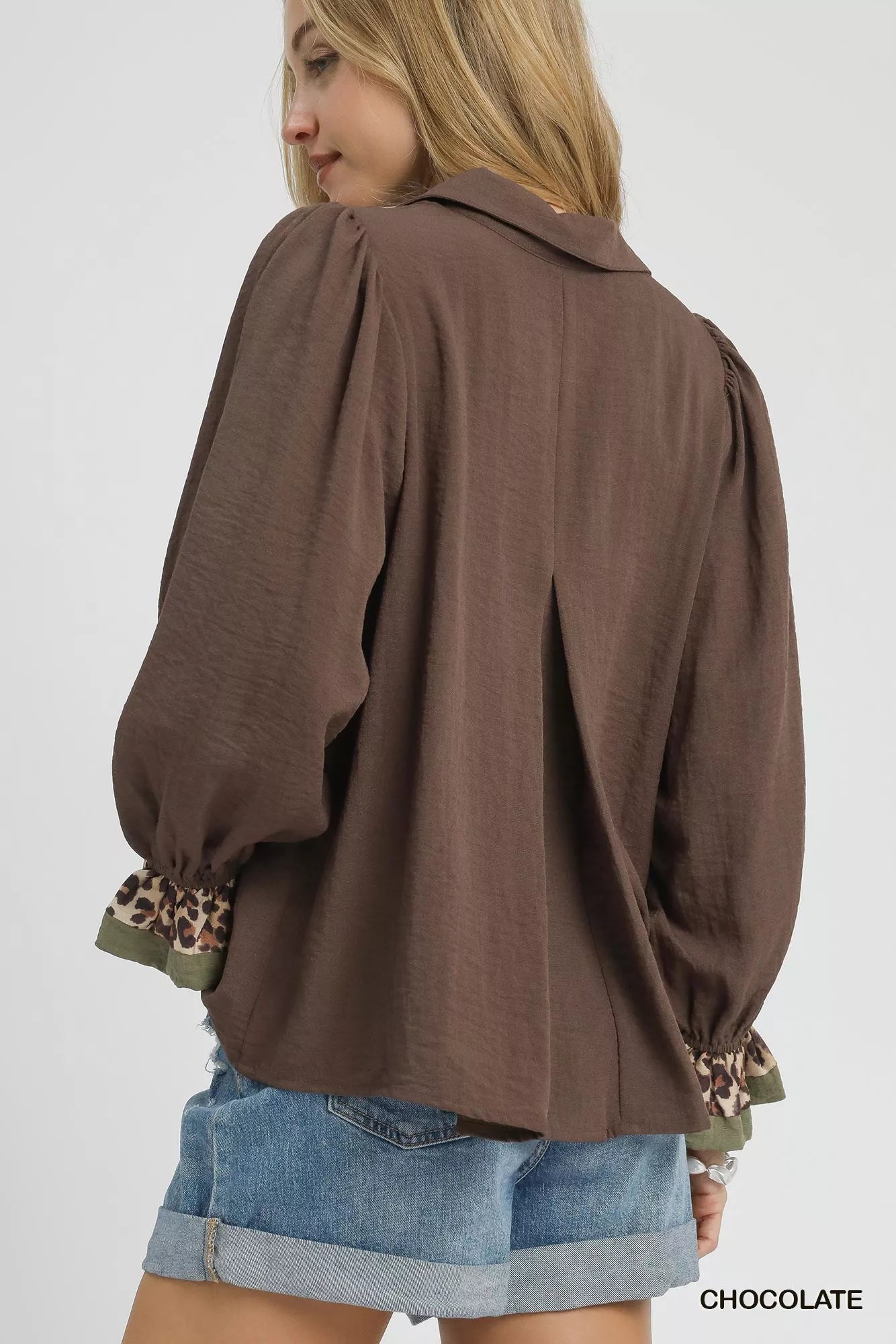 Back view of women's half button blouse in chocolate with leopard print trim on cuffs.