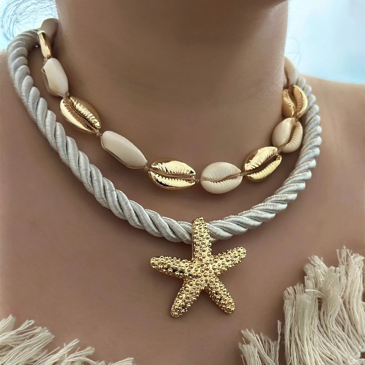 Gold-tone boho necklace set with shell beads, rope chain, and starfish pendant on model.