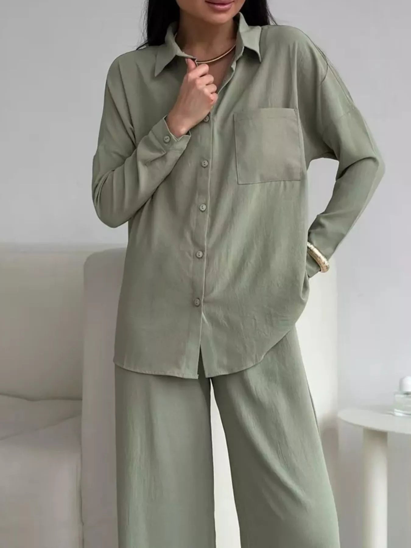 Woman modeling a two-piece sage green button-down shirt and wide-leg pants set with pockets.
