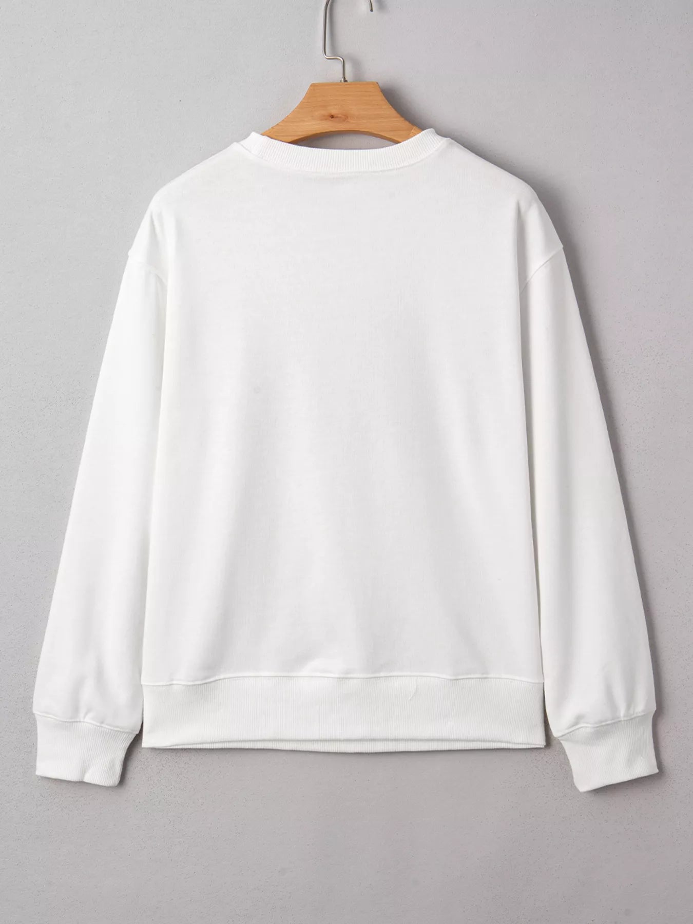 White crew neck sweatshirt with football 3D graphic on front, long sleeves, and poly-cotton blend fabric.