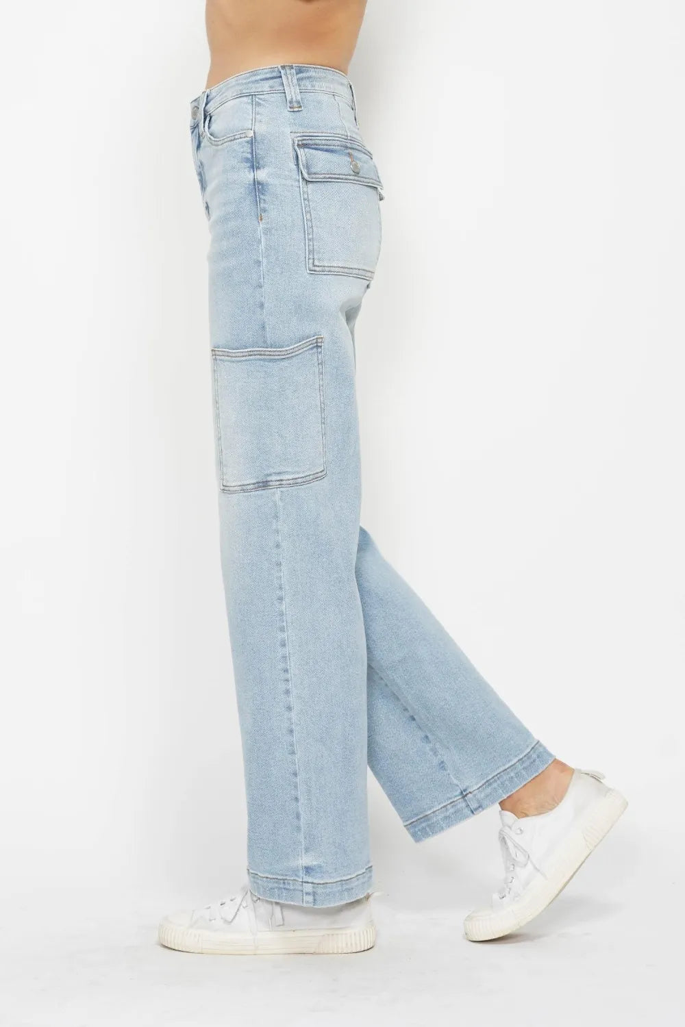 High-waist straight-leg cargo jeans in light wash with multiple pockets, modeled on a person wearing white sneakers.
