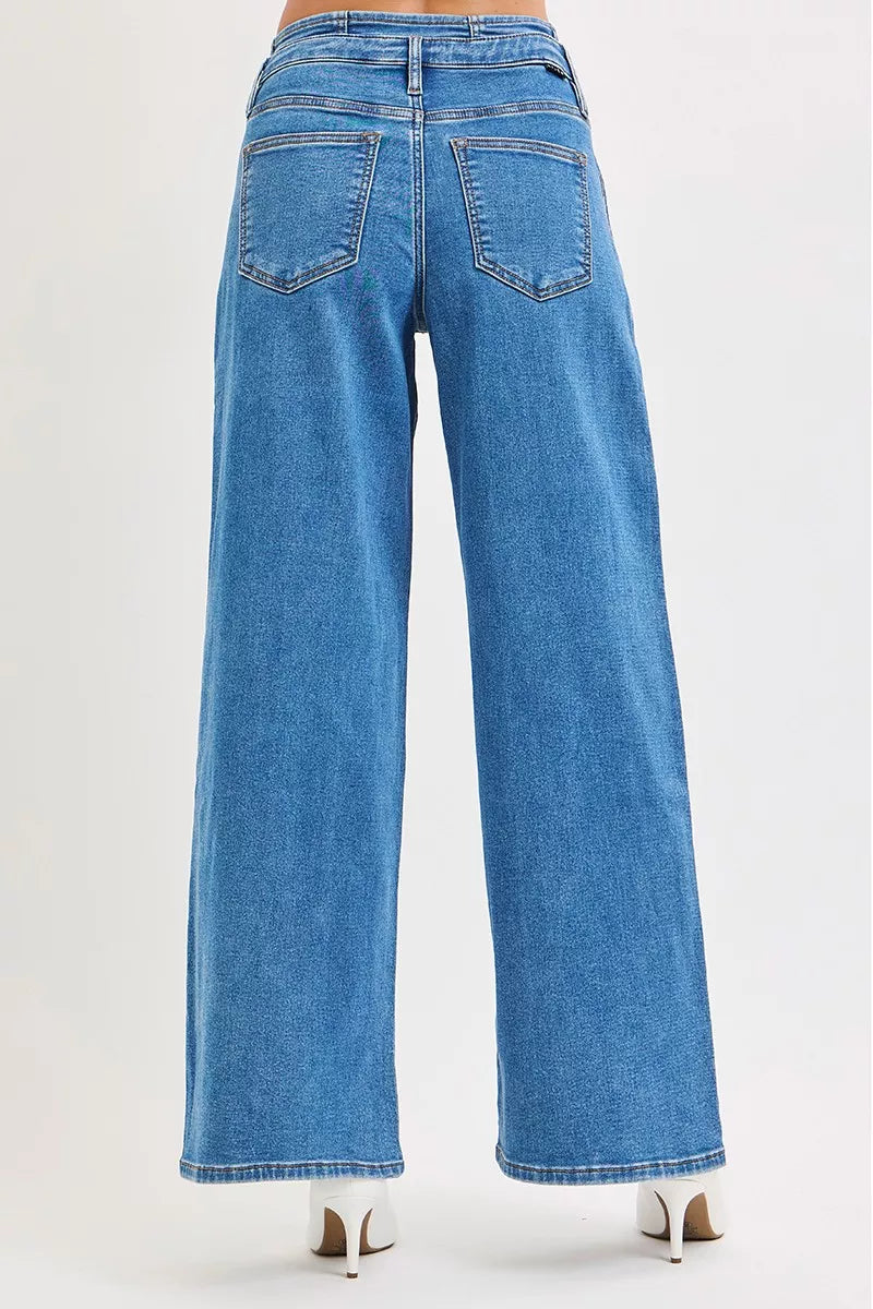 Rear view of plus size mid-rise wide leg pleated jeans in light blue denim.
