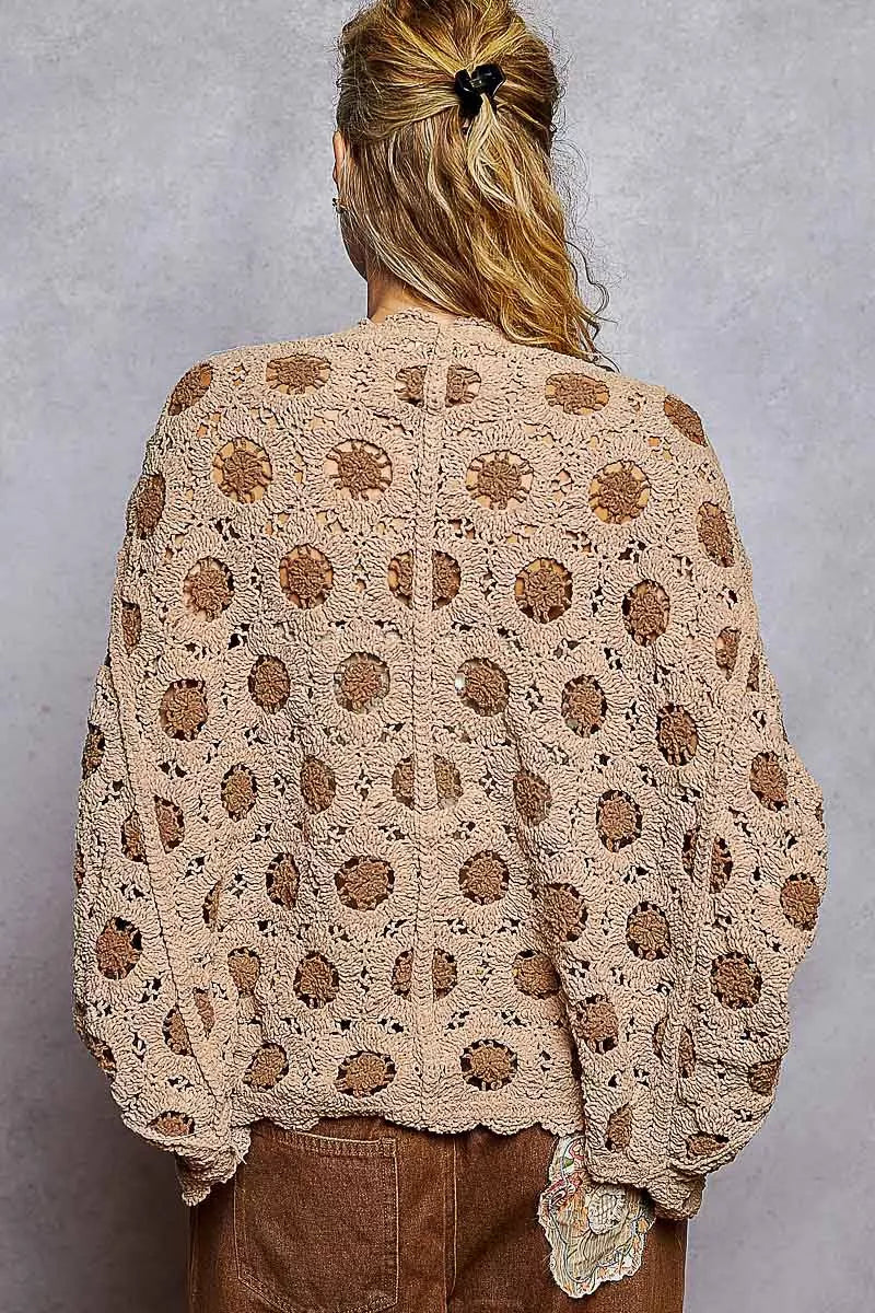 Back view of openwork chenille cardigan with floral contrast and batwing sleeves.