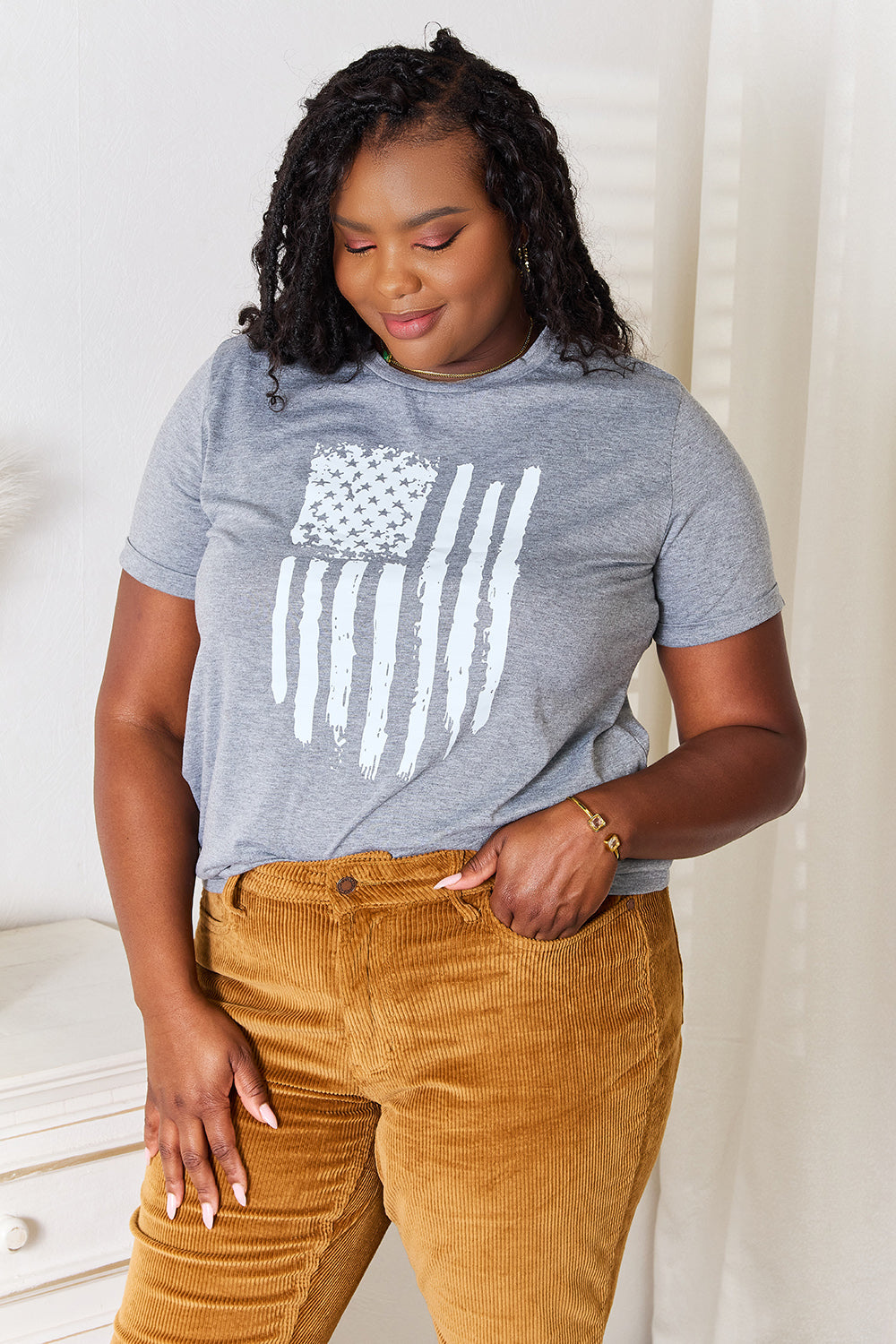 White cuffed sleeve t-shirt with US flag graphic on front made of polyester blend
