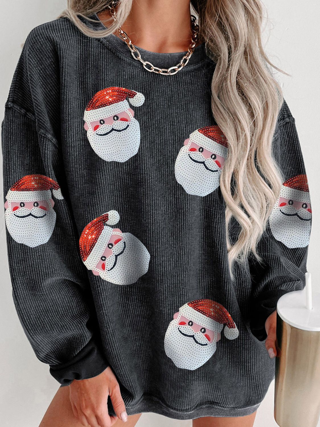 Gray ribbed sweatshirt with sequin Santa patches and a model wearing it.