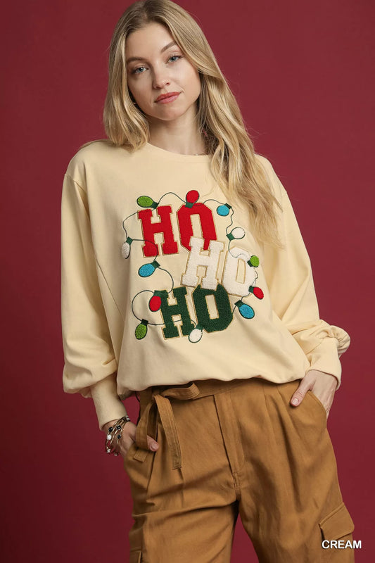 Cream-colored French terry sweatshirt with HO applique and string lights.