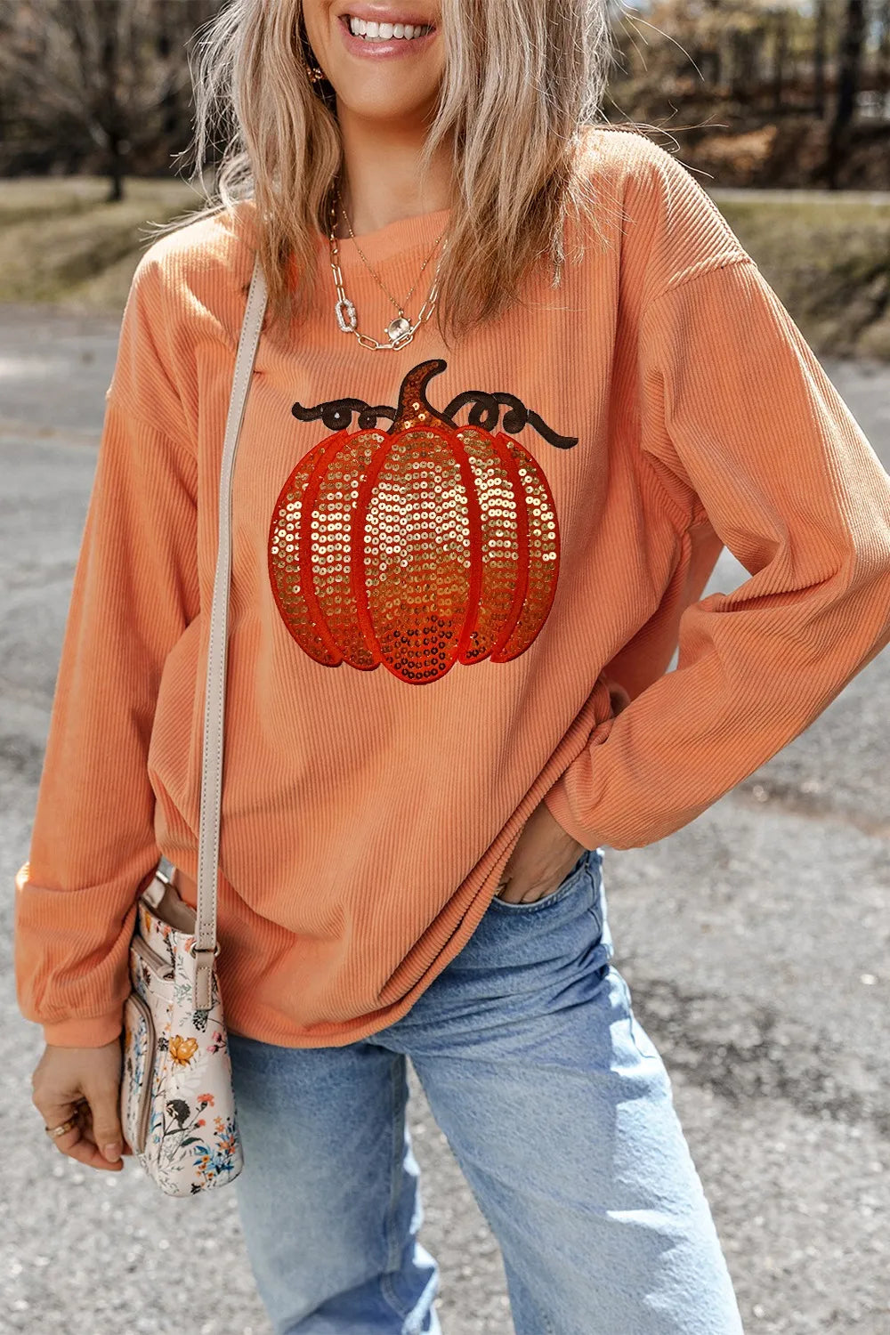 Long sleeve round neck sweatshirt featuring a sequin pumpkin design on a cozy fabric.