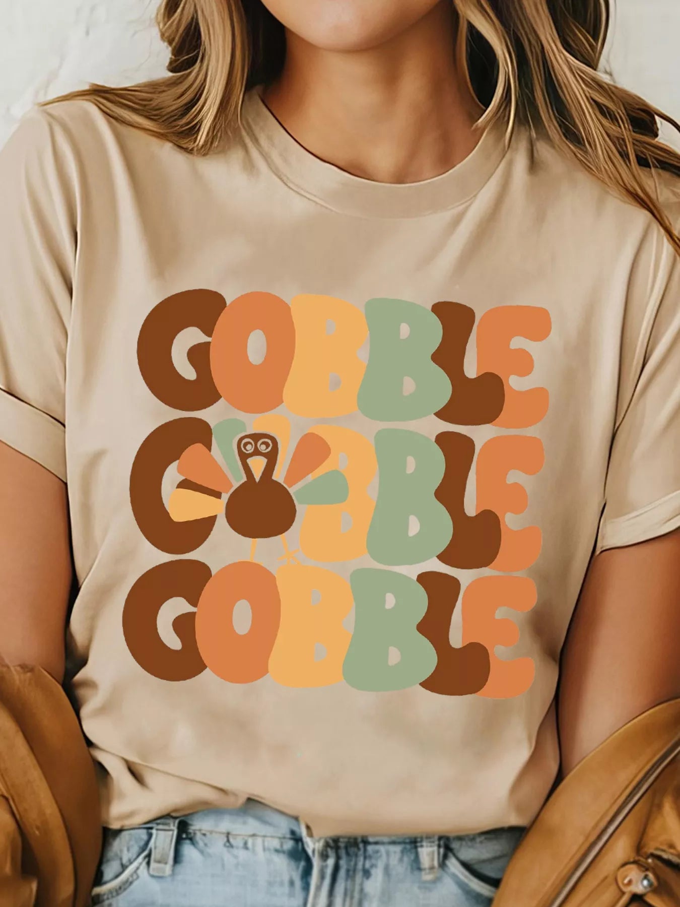 Beige round neck T-shirt with colorful "Gobble" text and turkey graphic.