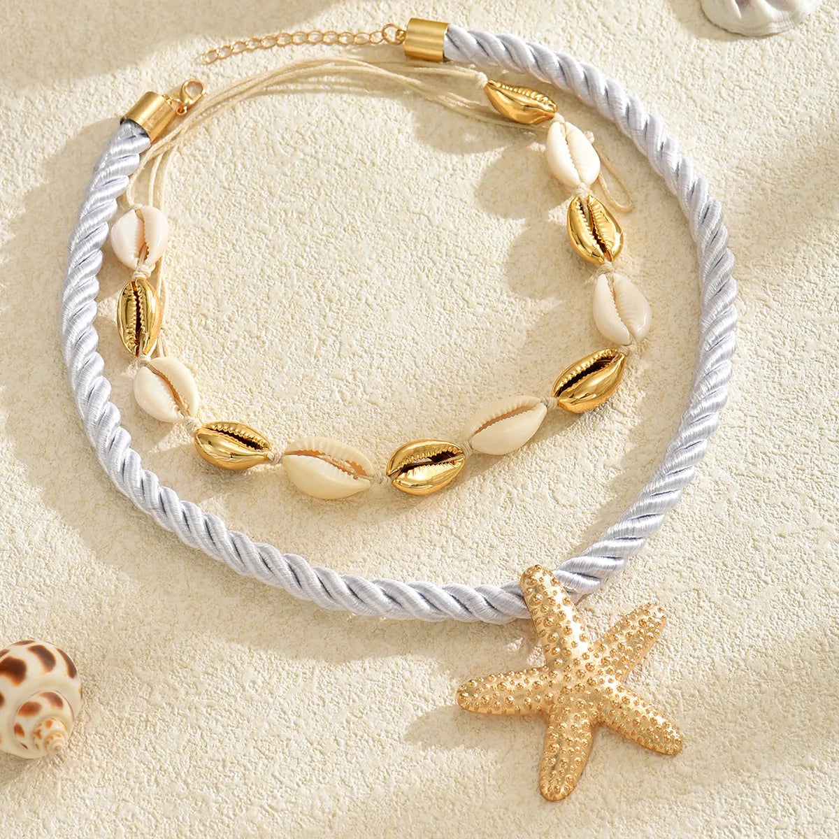 Gold-tone boho necklace set with shell beads, starfish pendant, and white rope chains.