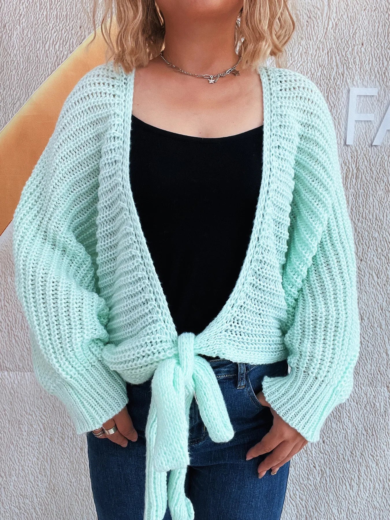 Light blue tie-front long sleeve cardigan modeled on a woman.