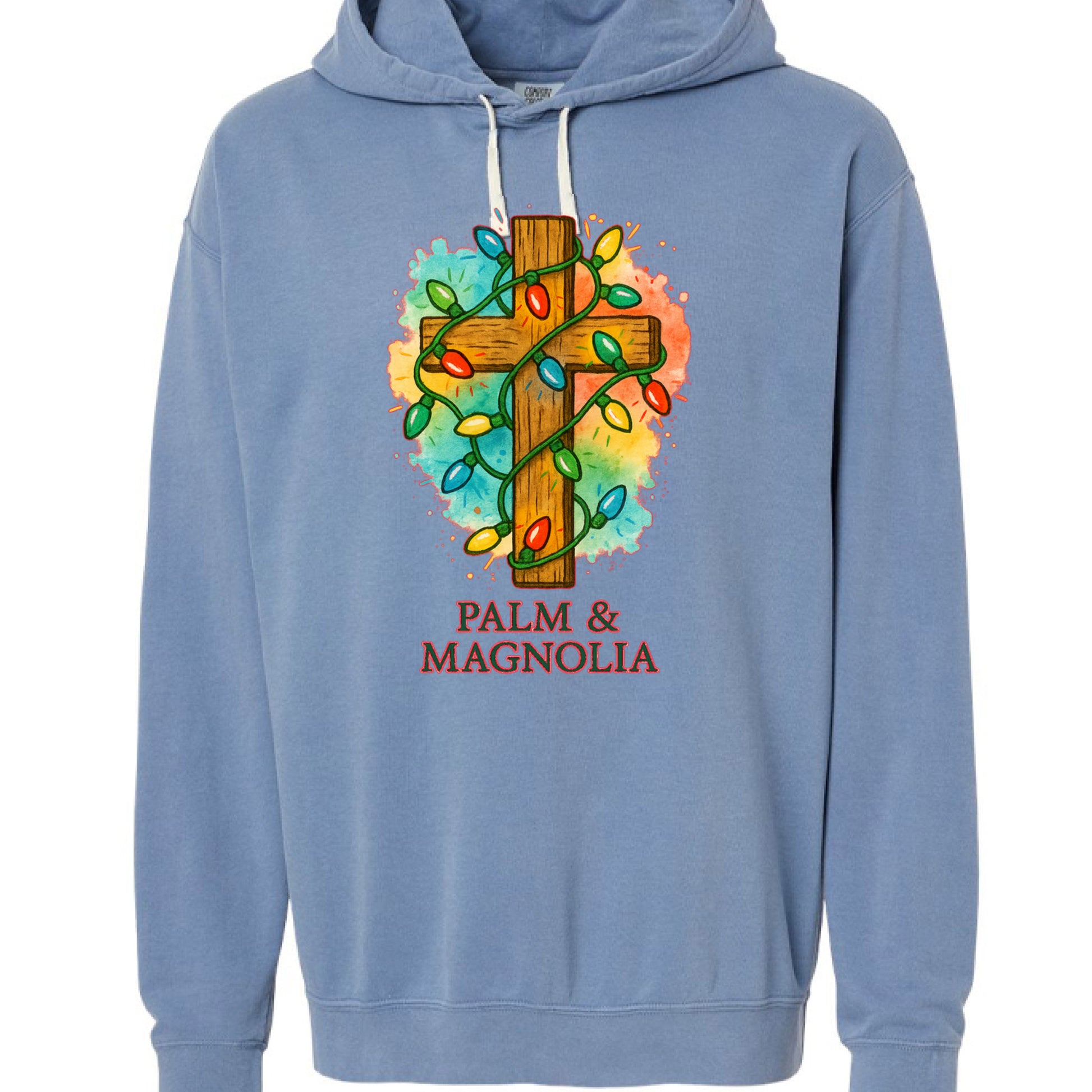 Blue hoodie with rustic wooden cross wrapped in colorful Christmas lights and "Palm & Magnolia" text.