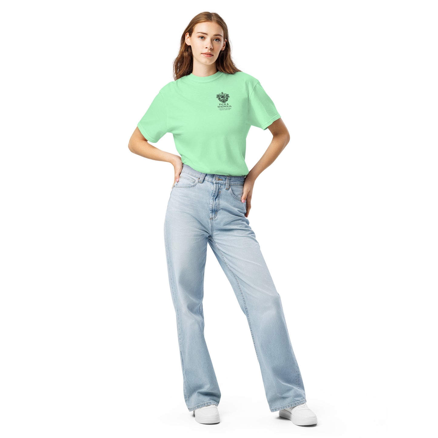 A woman models a light green Comfort Colors tee with a Coastal Companions Hard Rock Bronco graphic.