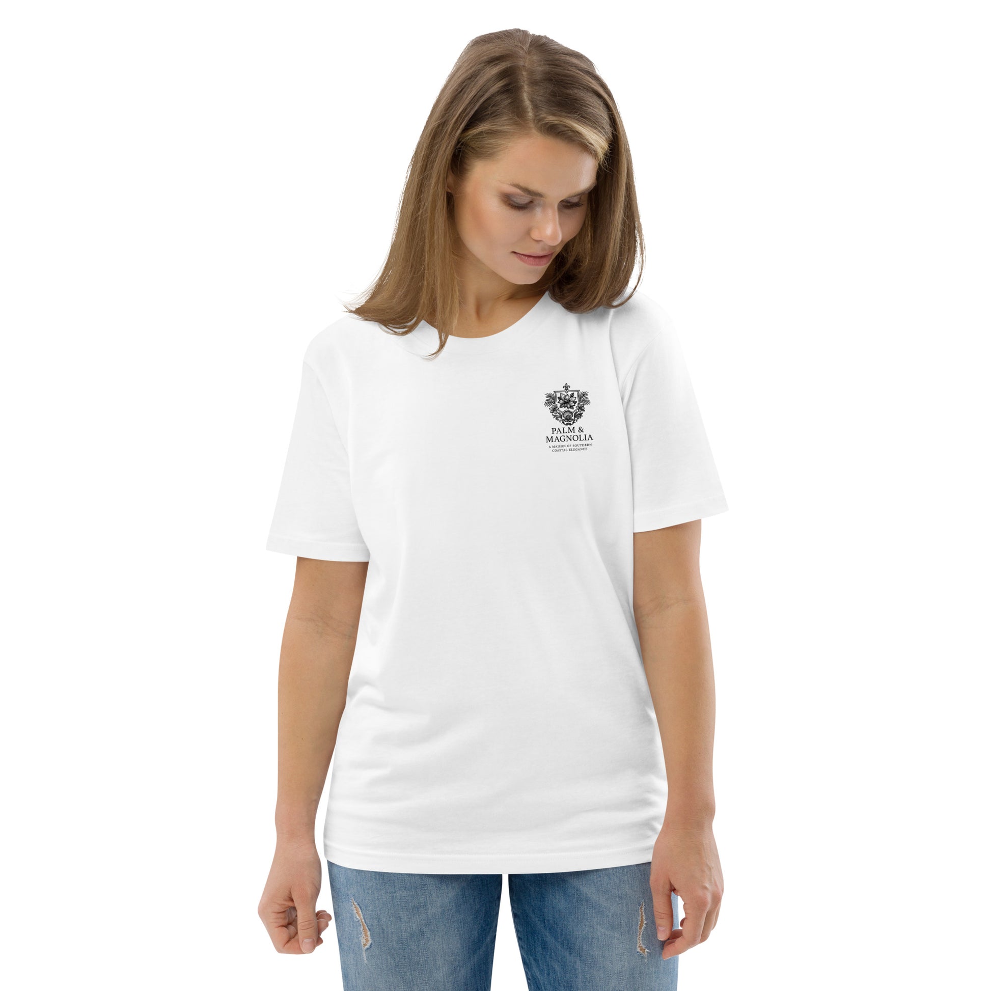 Woman modeling a white organic cotton tee with a small emblem on the chest.