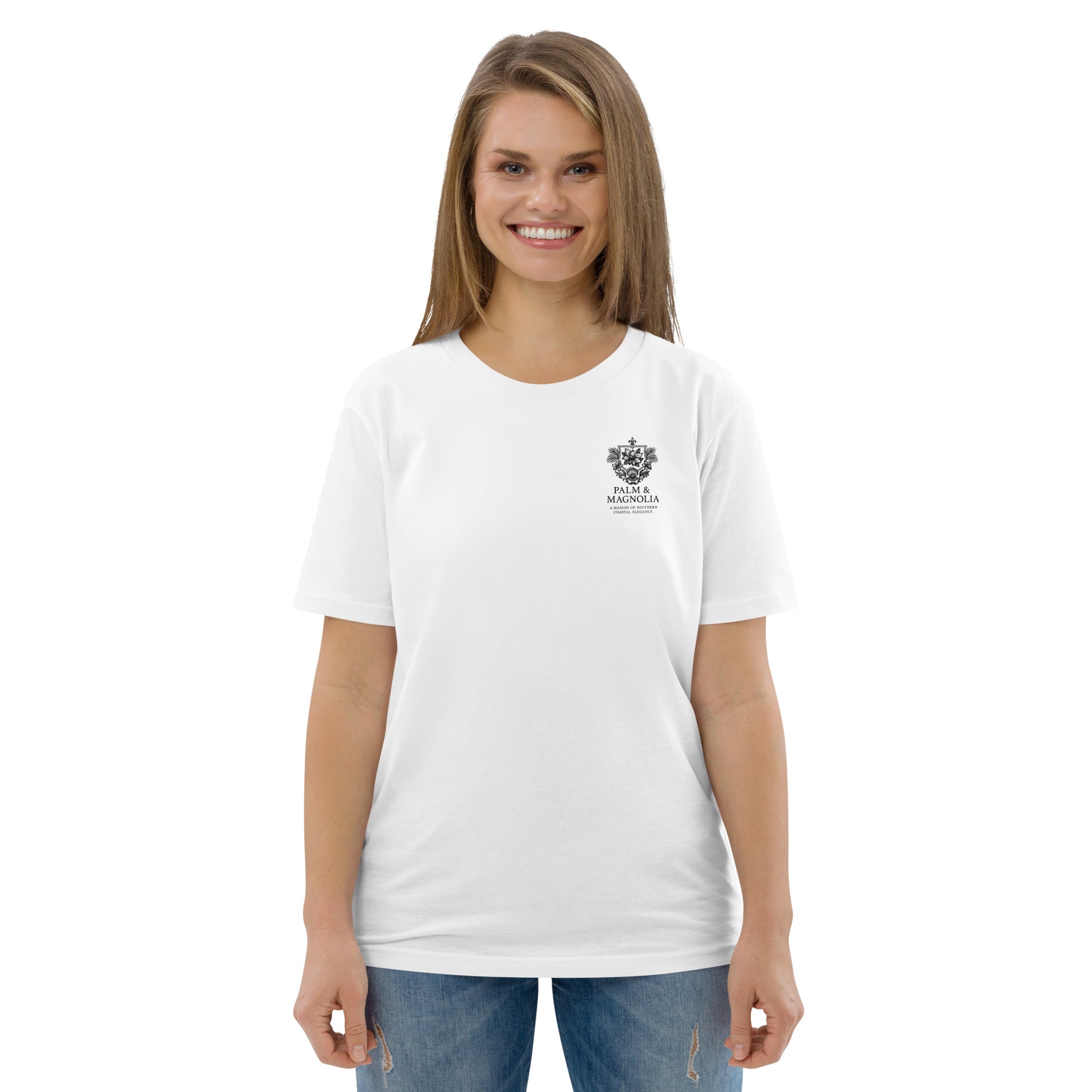 Woman modeling a white organic cotton t-shirt with a small crest emblem on the chest.