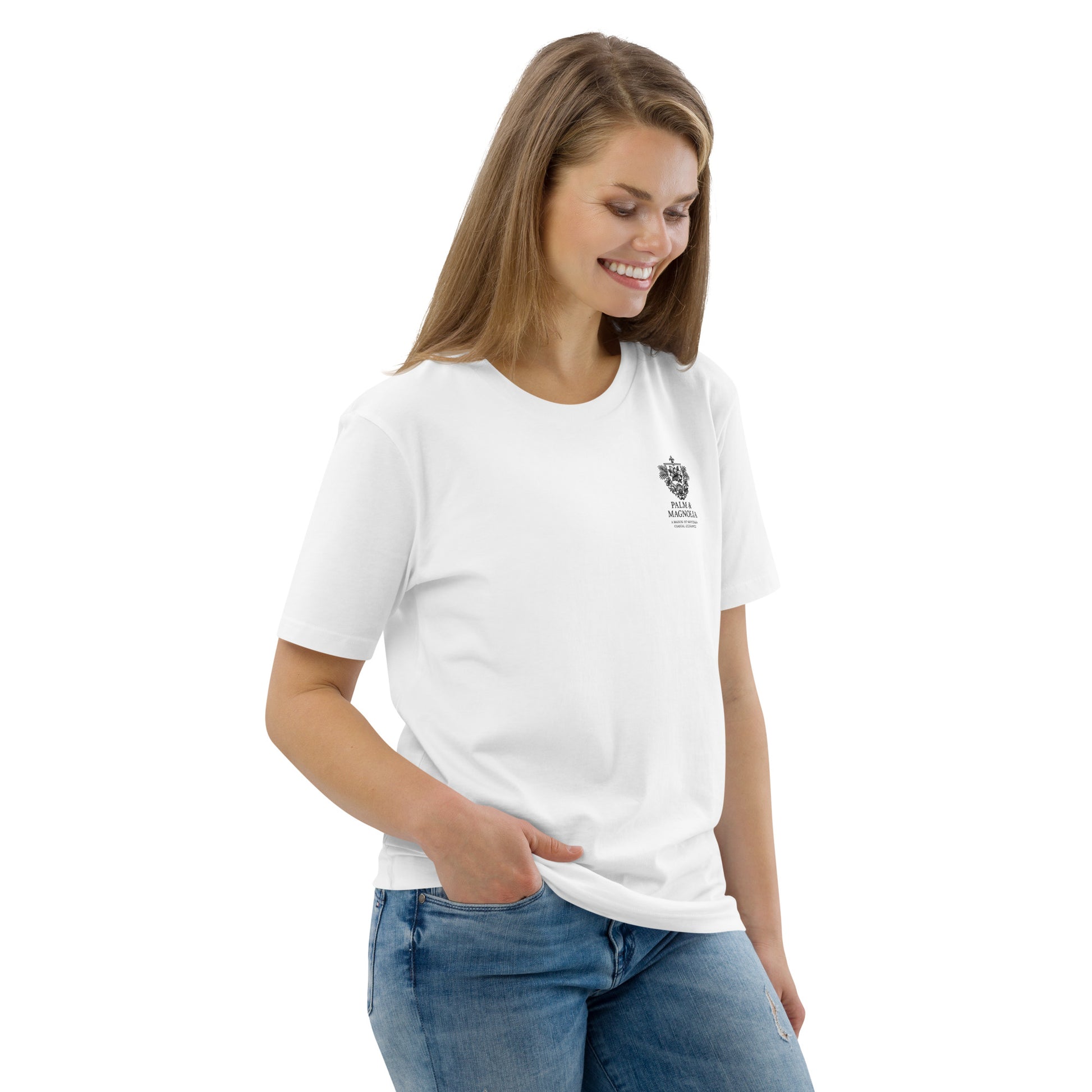 Woman wearing a white organic cotton t-shirt with a black palm and magnolia print on the chest, paired with jeans.