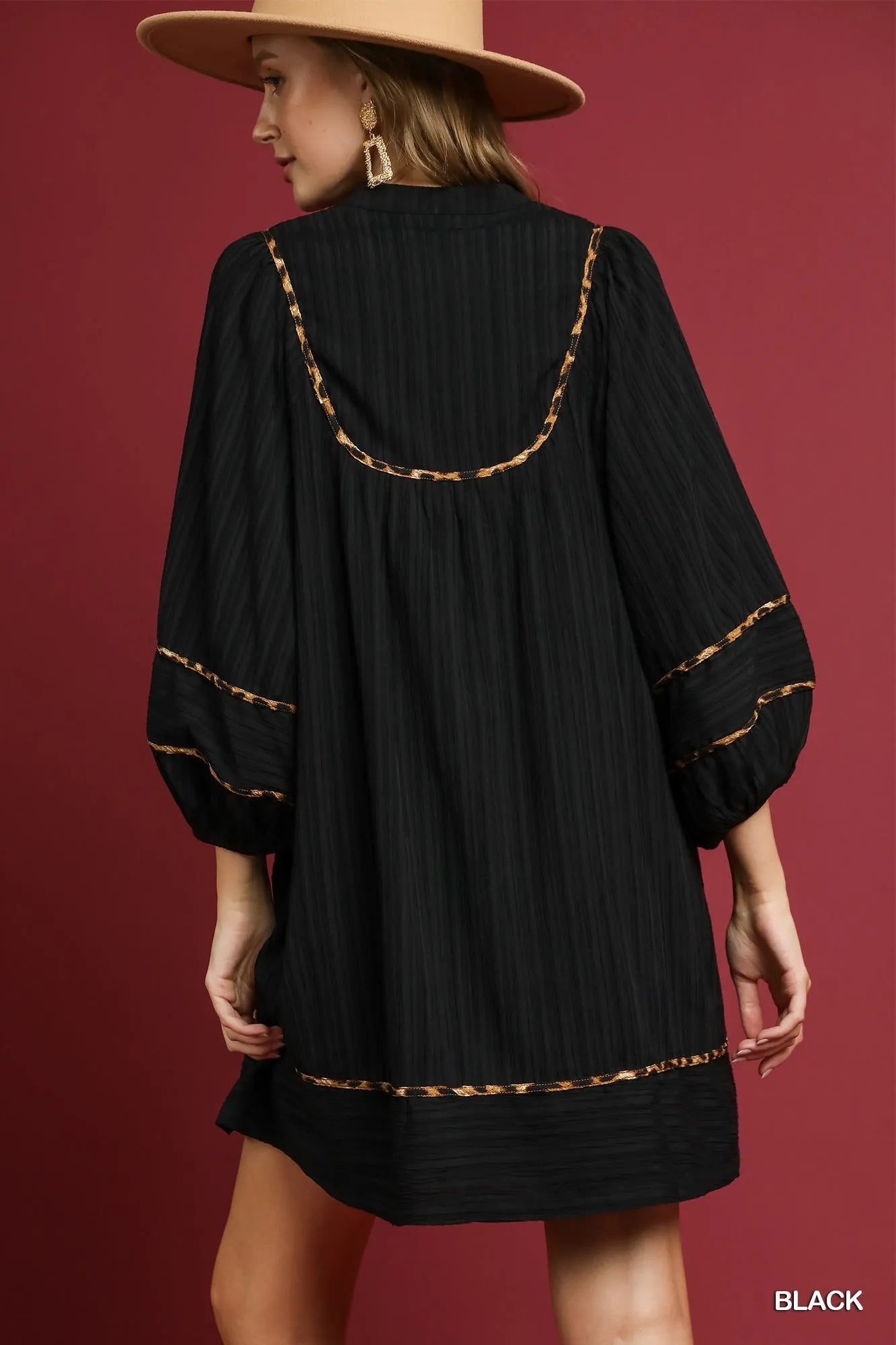 Back view of plus size black textured babydoll dress with leopard trim.