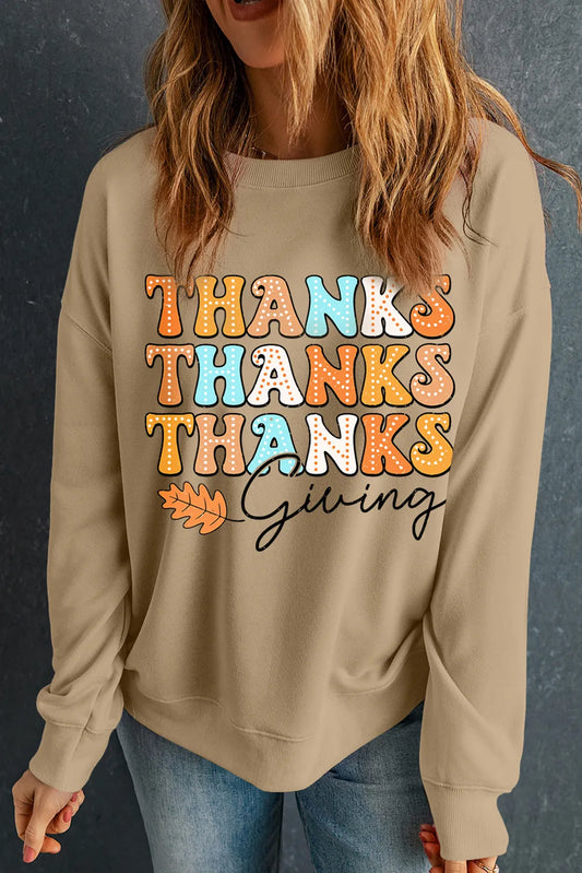 Beige dropped shoulder sweatshirt with colorful "Thanks Giving" text and leaf graphic.