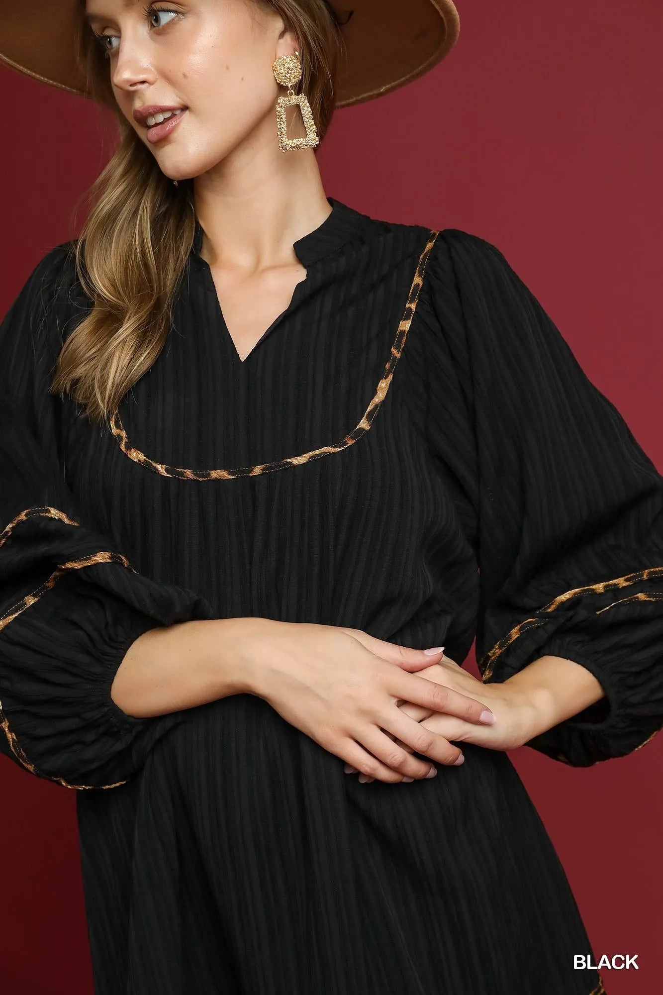 Plus-size textured babydoll dress in black with leopard trim and puffed sleeves.