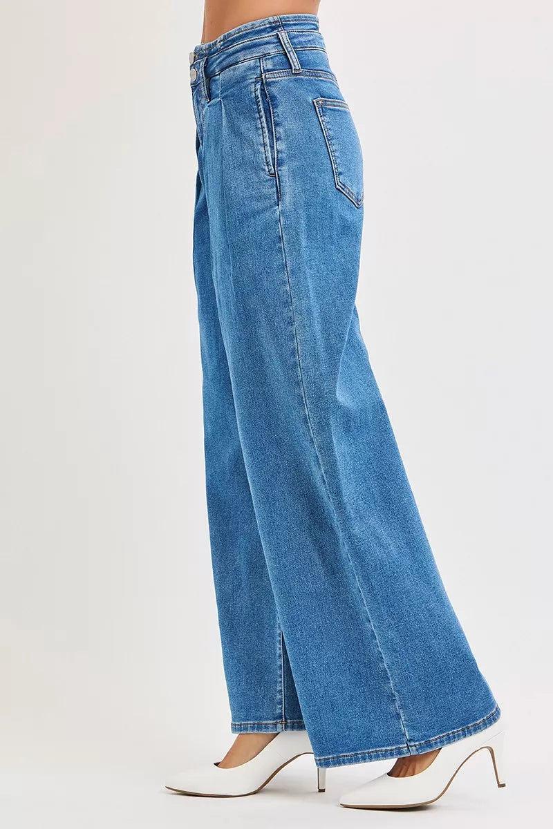 Side view of plus size mid-rise wide-leg pleated jeans in light blue denim.