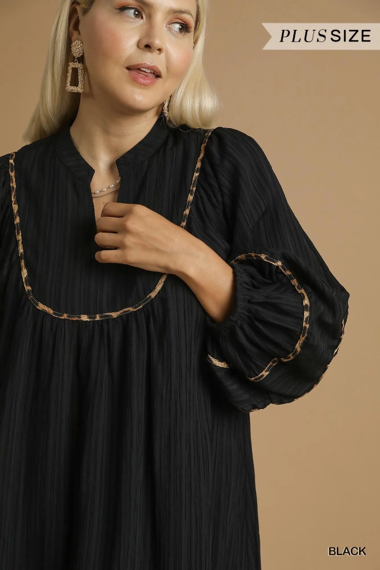 Plus size black textured babydoll dress with leopard trim.
