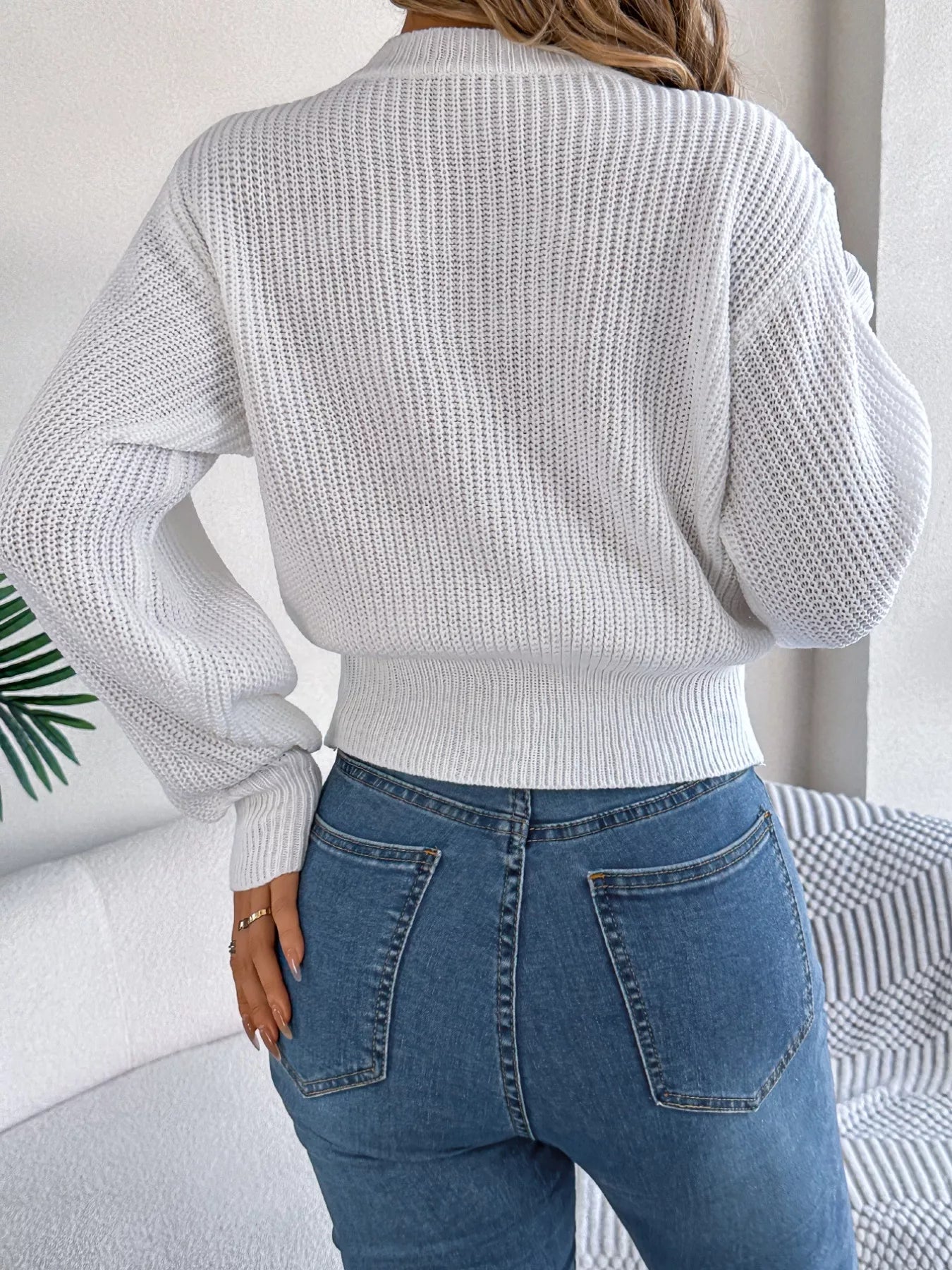 A cream cable knit sweater with a diamond pattern and long sleeves made of acrylic and spandex.