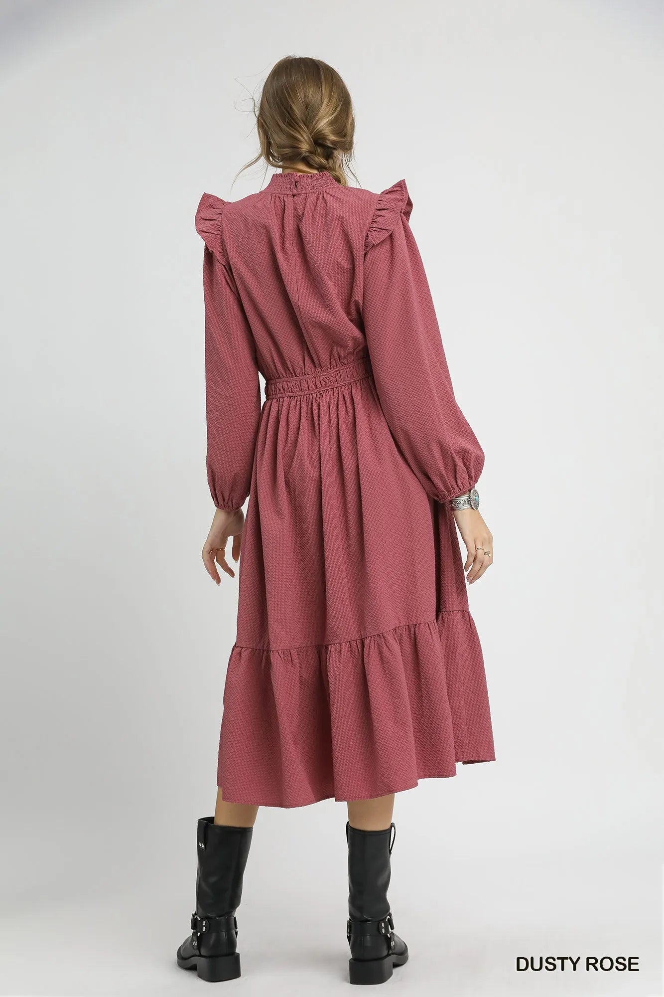 Back view of dusty rose textured midi dress with ruffle shoulders and cuffs.