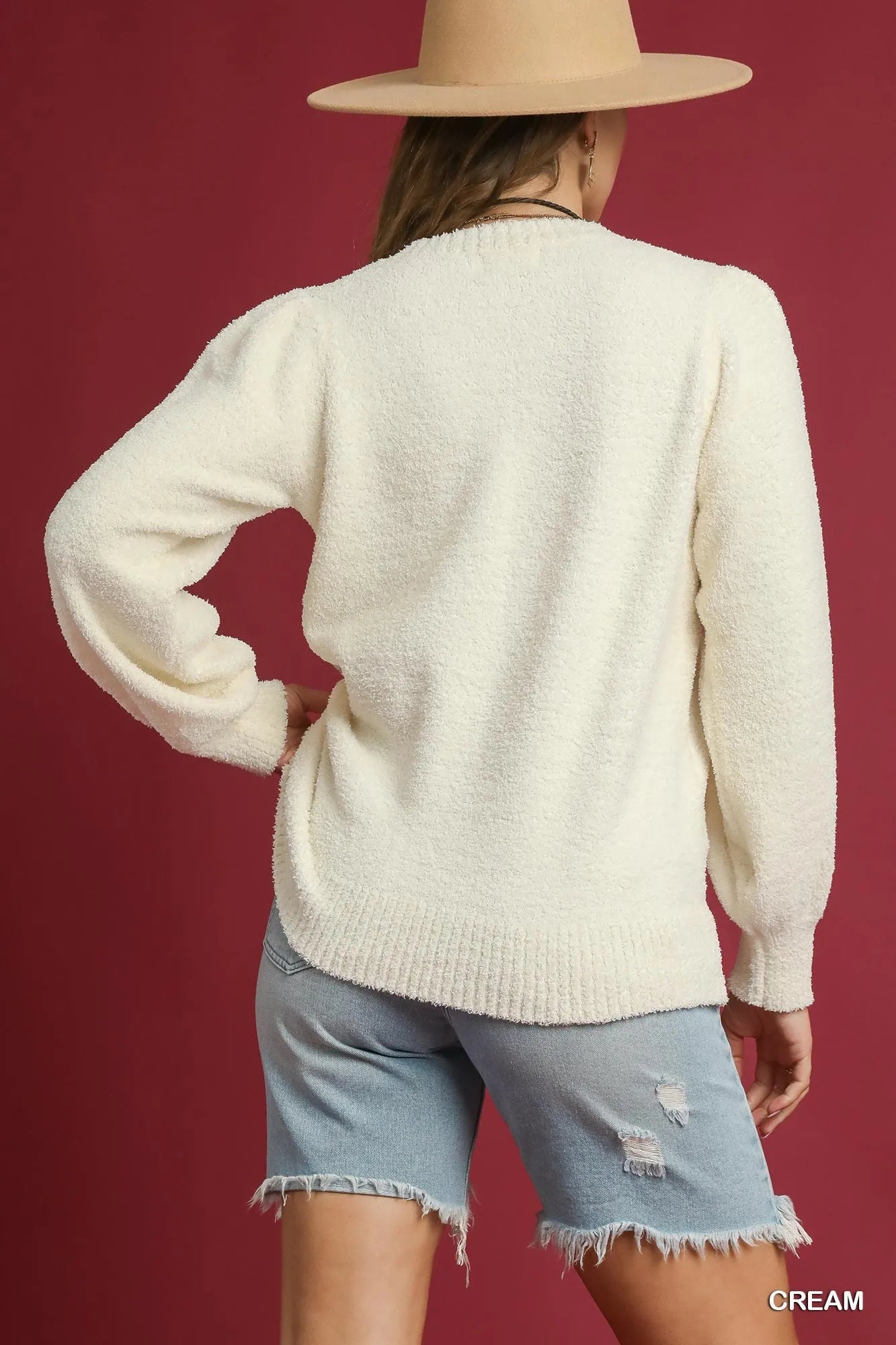 Woman modeling a textured long-sleeve acrylic sweater with ribbed trim and oversized fit.