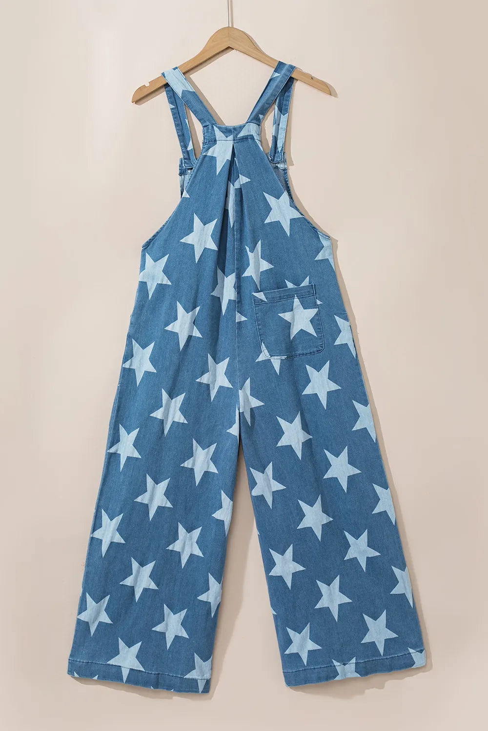Wide leg denim overalls with star print and pockets, made from a cotton blend.