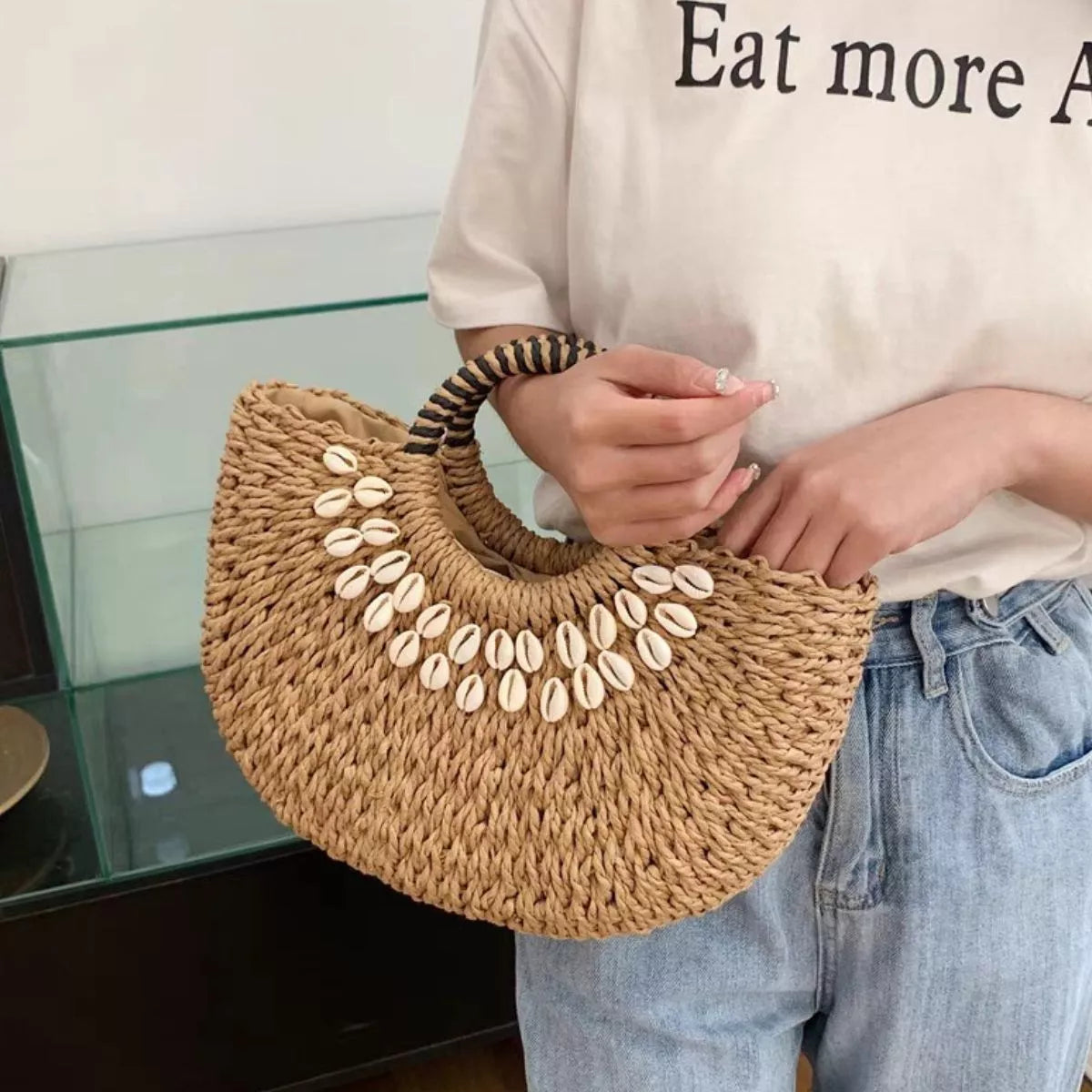 Small woven straw handbag with seashell embellishments, measuring 7.9 by 11.8 inches.