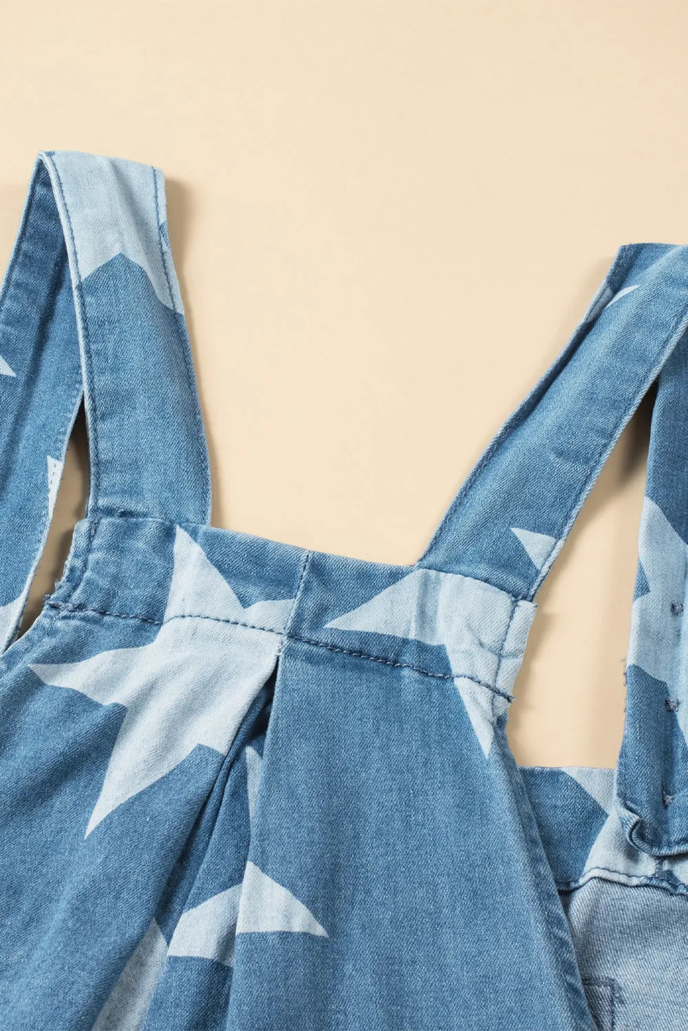 Wide leg denim overalls with star print and front pockets, made from a cotton blend.
