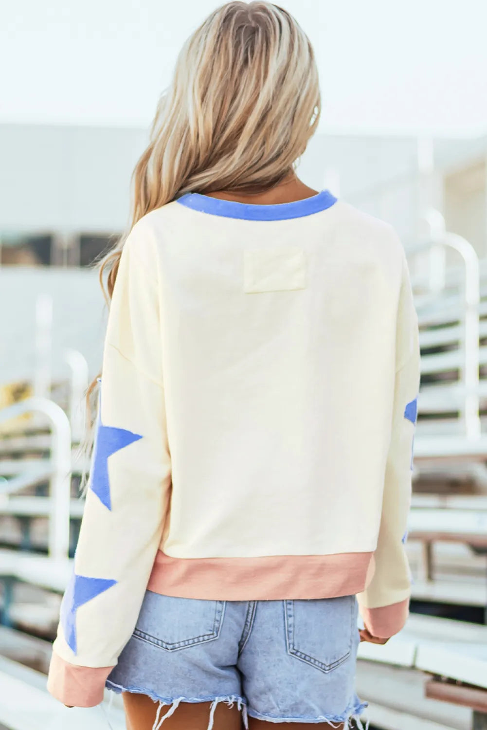 Round neck long sleeve sweatshirt with a star patch in basic opaque fabric.
