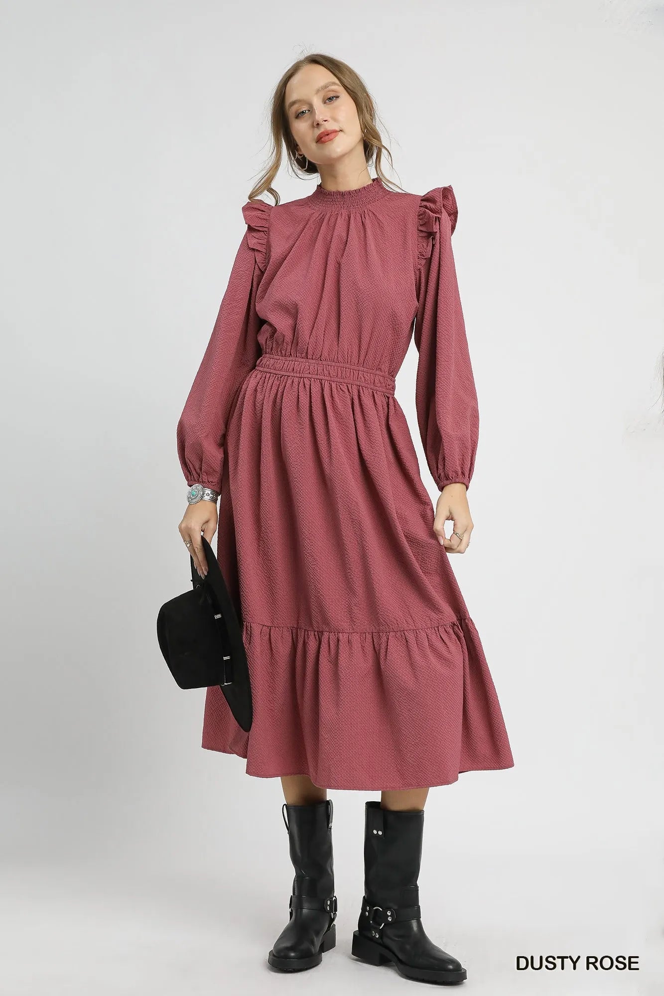 Dusty rose textured midi dress with ruffle shoulders and cuffs on a model.