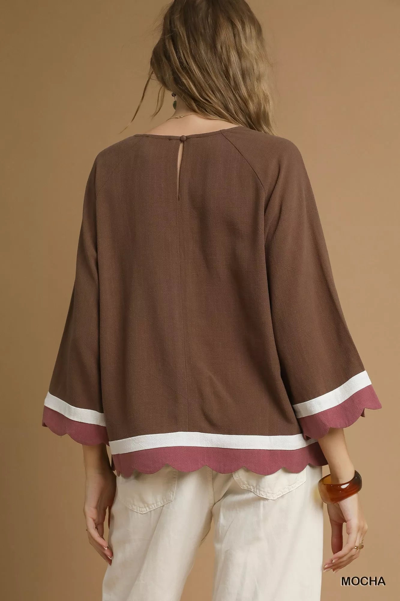 Rear view of Umgee scalloped hem color block linen blend top in mocha with white trim.