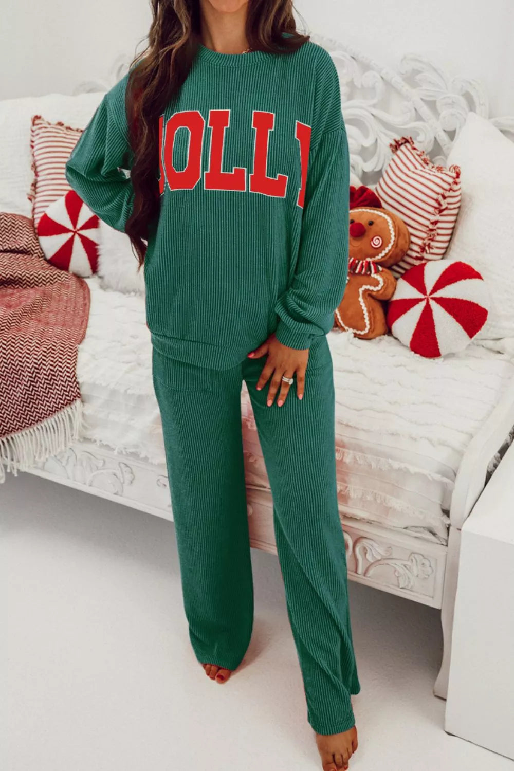Woman wearing a green Jolly Christmas polyester top and drawstring pants set.