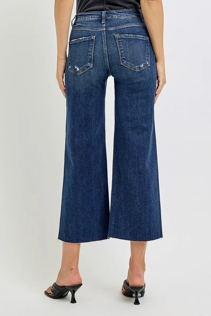 Rear view of medium wash high-rise wide-leg crop jeans on a model.