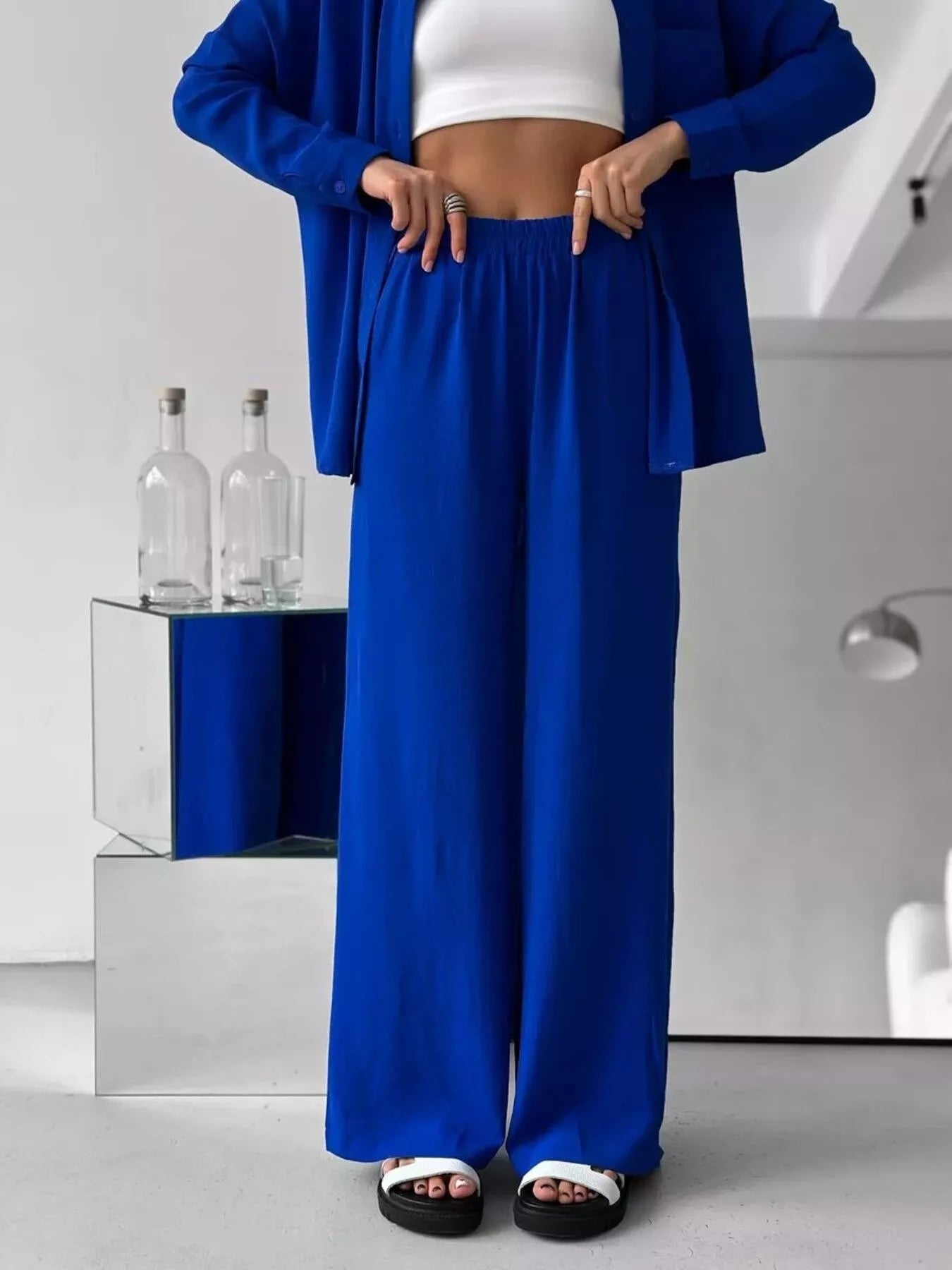 Woman modeling a blue two-piece button-down shirt and wide-leg pants set.
