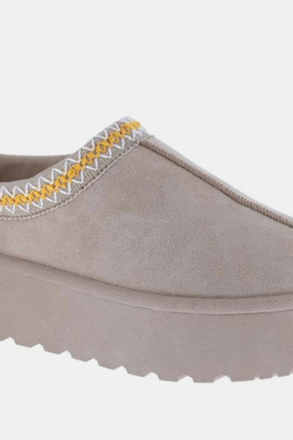 Gray suede platform slip-on boots with yellow embroidered trim.