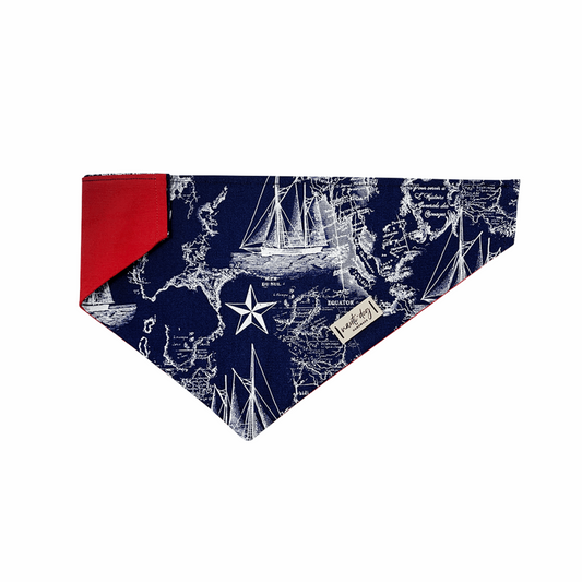Navy dog bandana with vintage nautical map print and red trim.