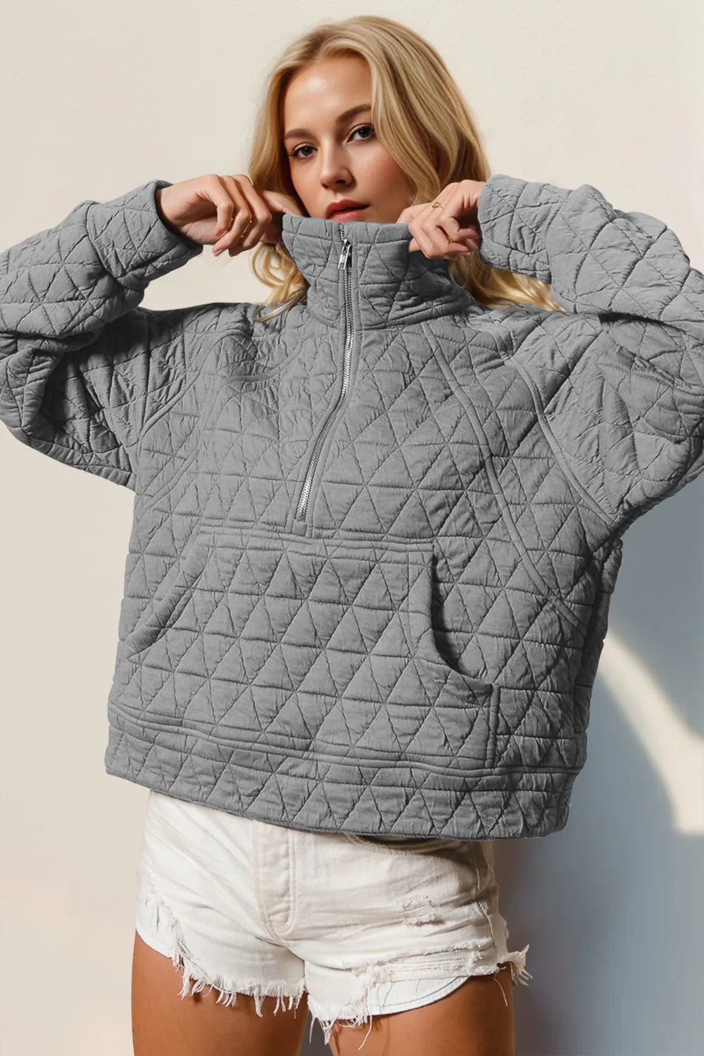 Half-zip quilted sweatshirt in gray with a sheer pocket and long sleeves.