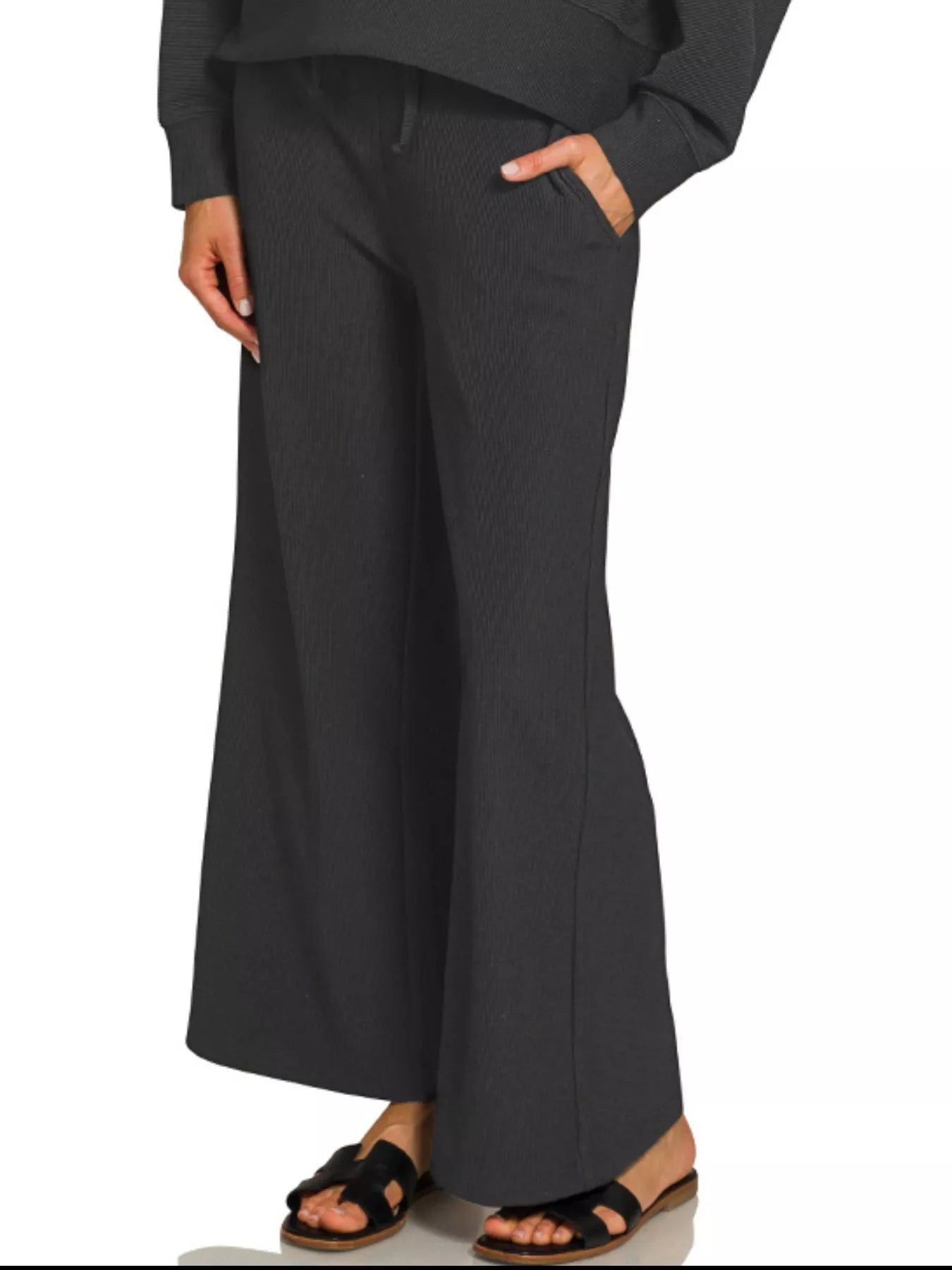 Woman wearing a ribbed round neck pullover and drawstring pants set in gray.