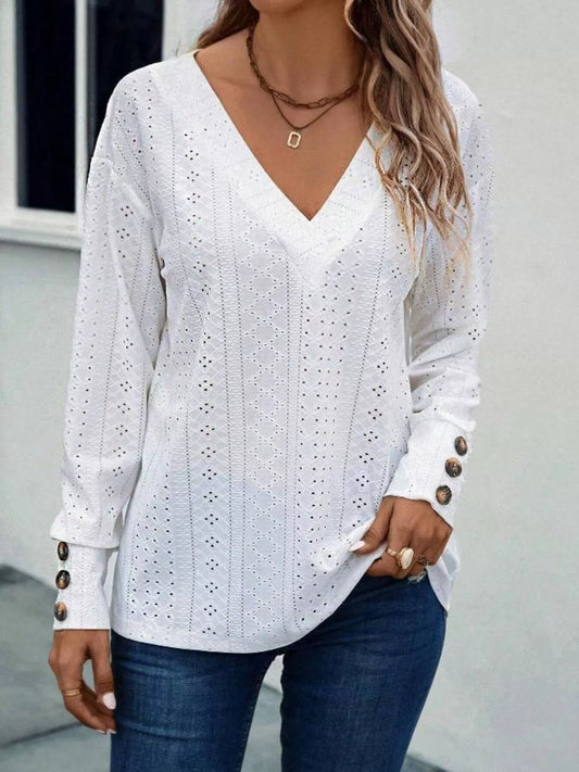 Long sleeve eyelet v-neck blouse in a polyester blend with decorative buttons.