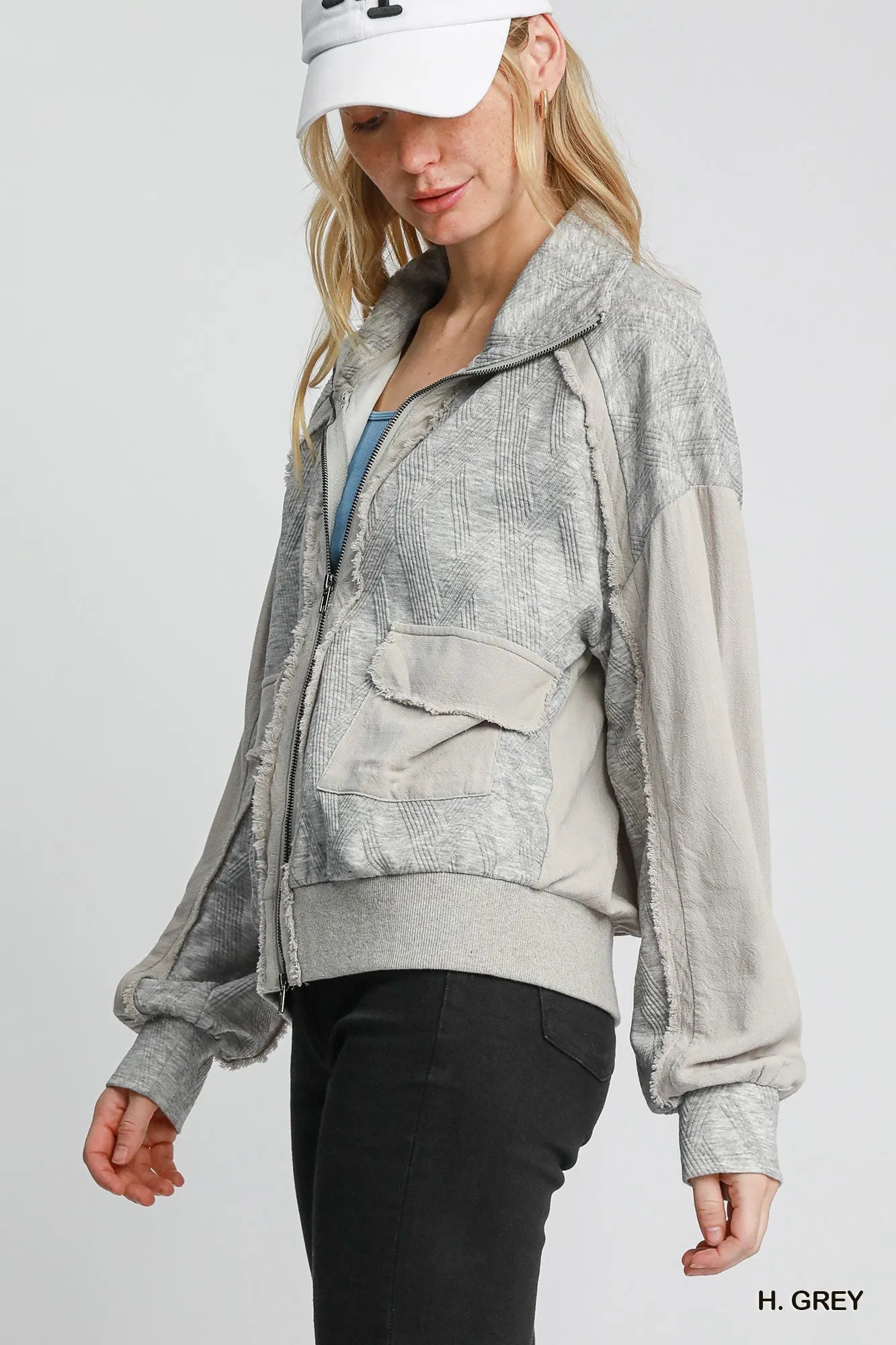 Woman modeling a two-way jacquard zip-up linen jacket in grey with textured fabric and pockets.