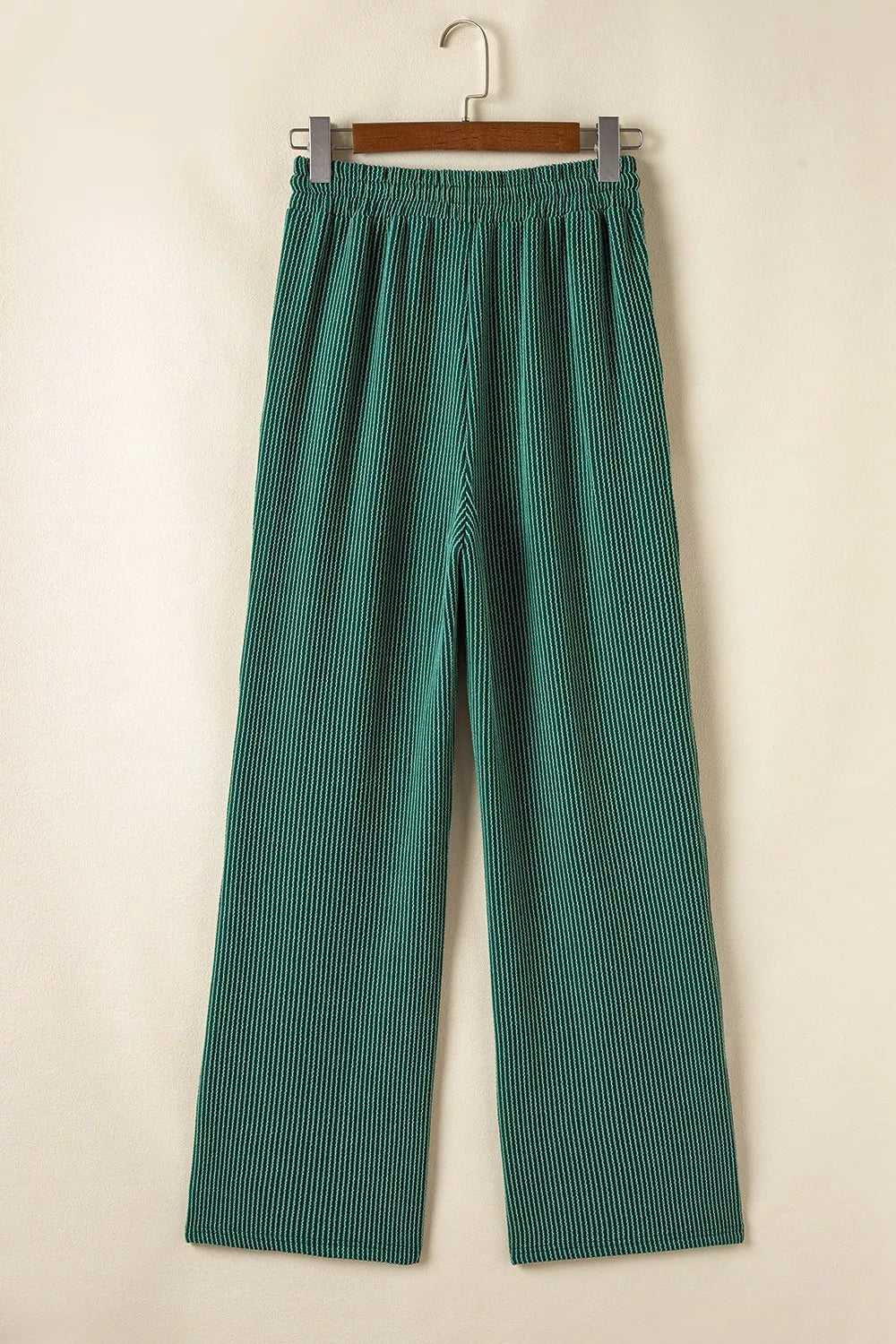 Green polyester drawstring pants with elastic waist, part of a two-piece set.