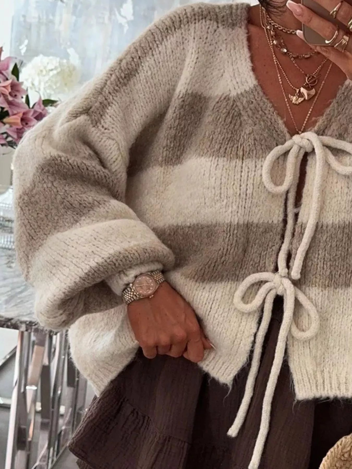 Striped knit cardigan with a tie-front, slightly stretchy fabric, and long sleeves.